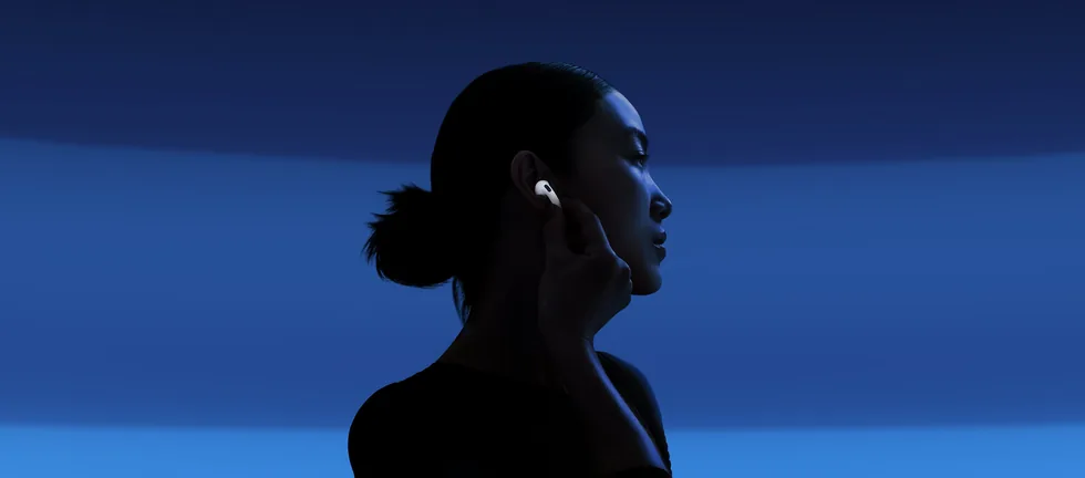 Žena v modrém světle se sluchátky AirPods 5