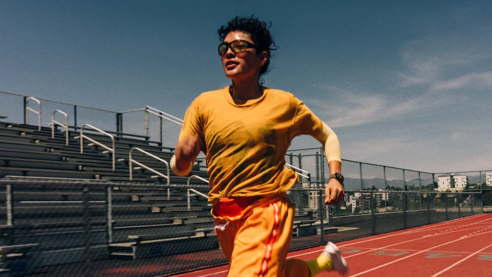 Běžec s hodinkami Apple Watch na atletické dráze