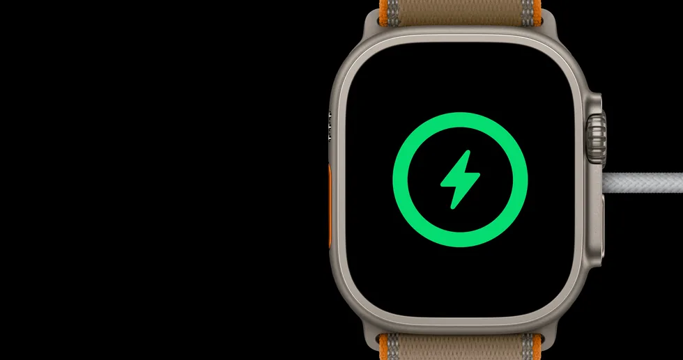Apple Watch Ultra 4 na nabíječce se symbolem nabíjení
