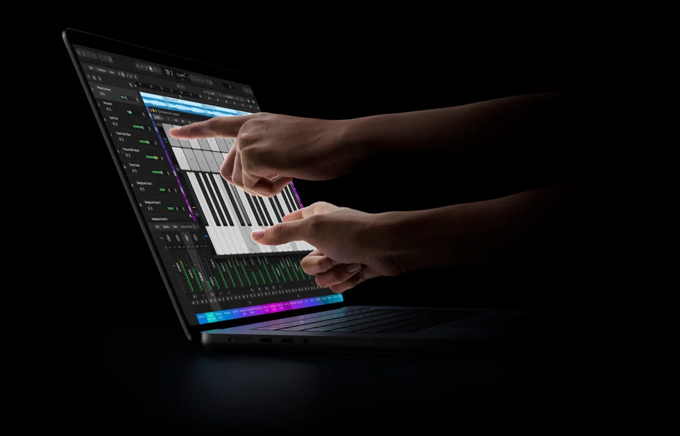 Ruce hrají na virtuální klaviaturu na displeji MacBooku Pro