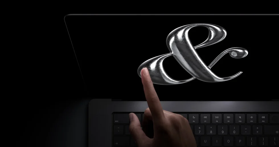 Prst se dotýká grafiky na displeji MacBooku Pro